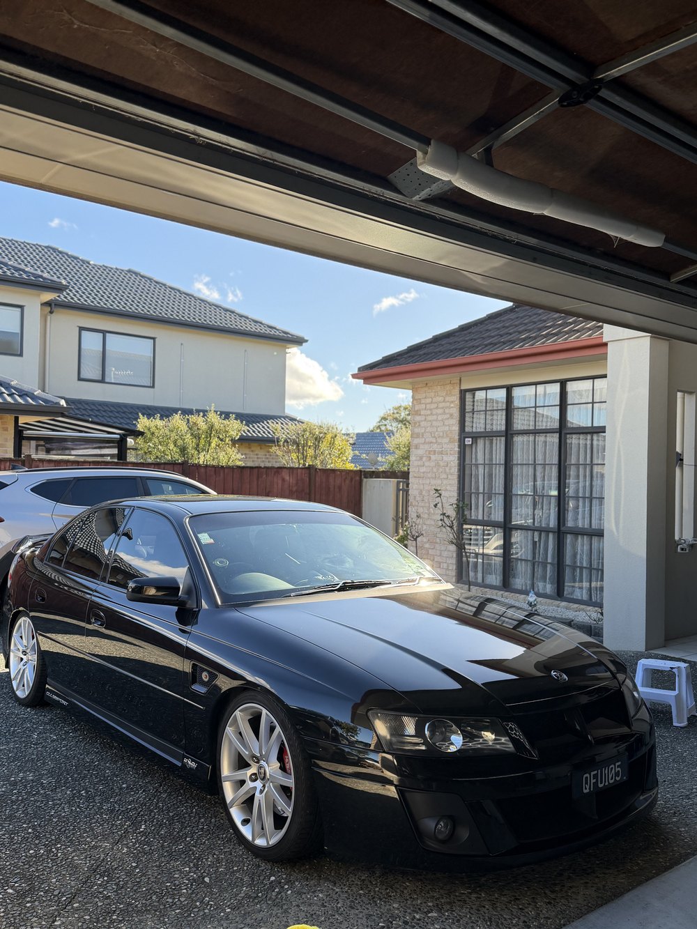 Black Holden Commodore under a carport after detailing