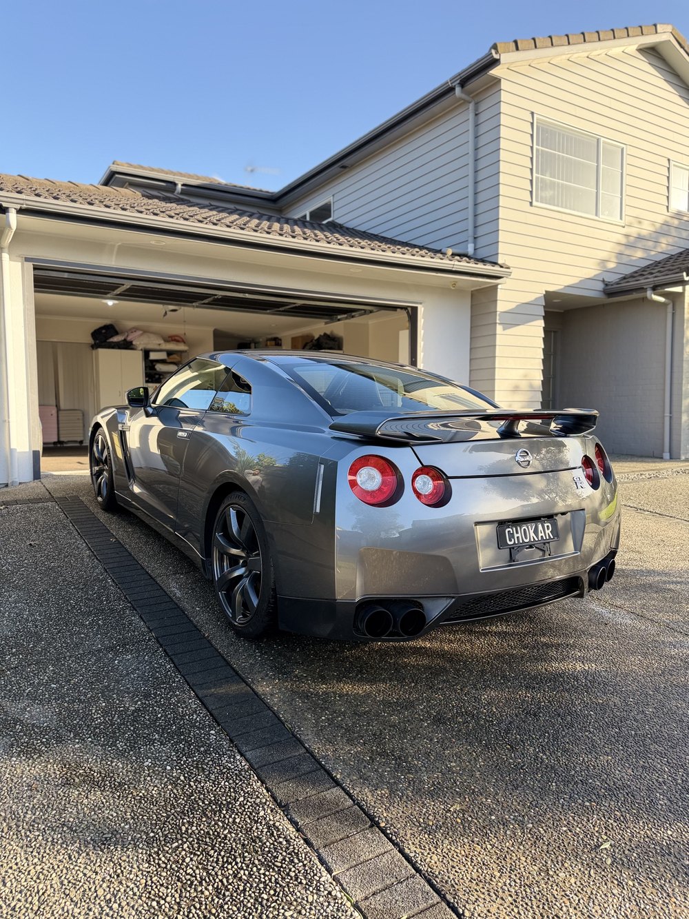 Nissan GT-R R35 rear three-quarter view on a clean driveway